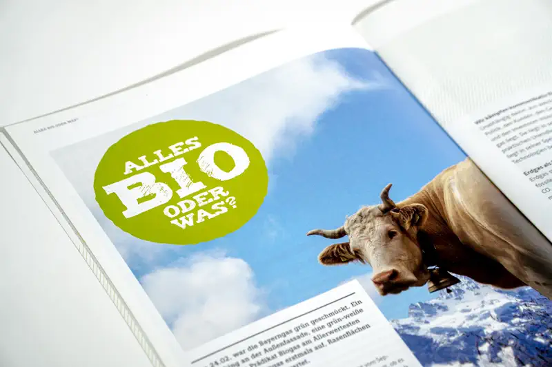 Broschüren-Innenseite mit Bild einer Kuh und einem grünen Bio-Siegel.