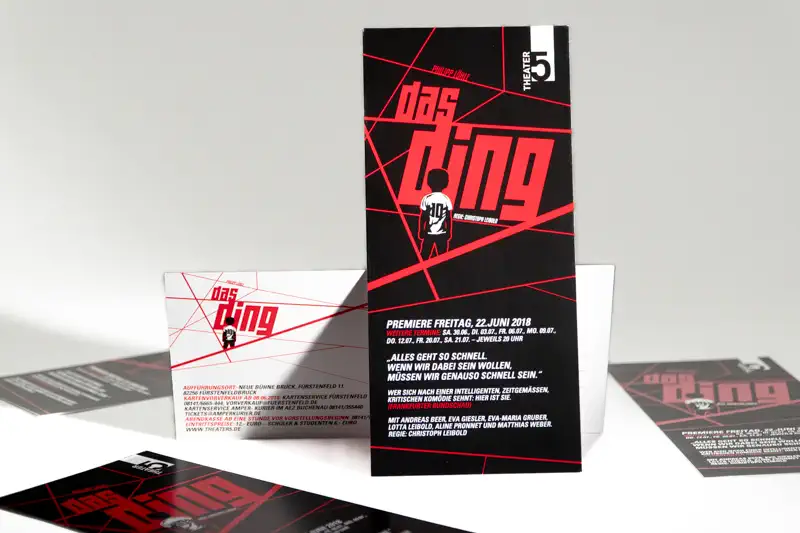 Flyer für Theaterstück „Das Ding“ Rote Schrift und schräge Linien auf schwarzem Untergrund.