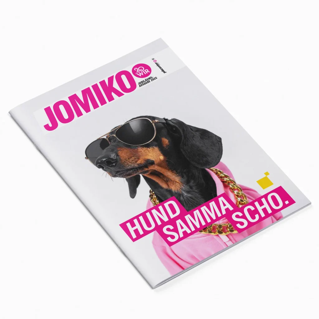 Cover of the employee magazine “JOMIKO.” The cover features a dachshund wearing sunglasses, a pink top, and gold chains, along with the caption “We’re already dogs.”